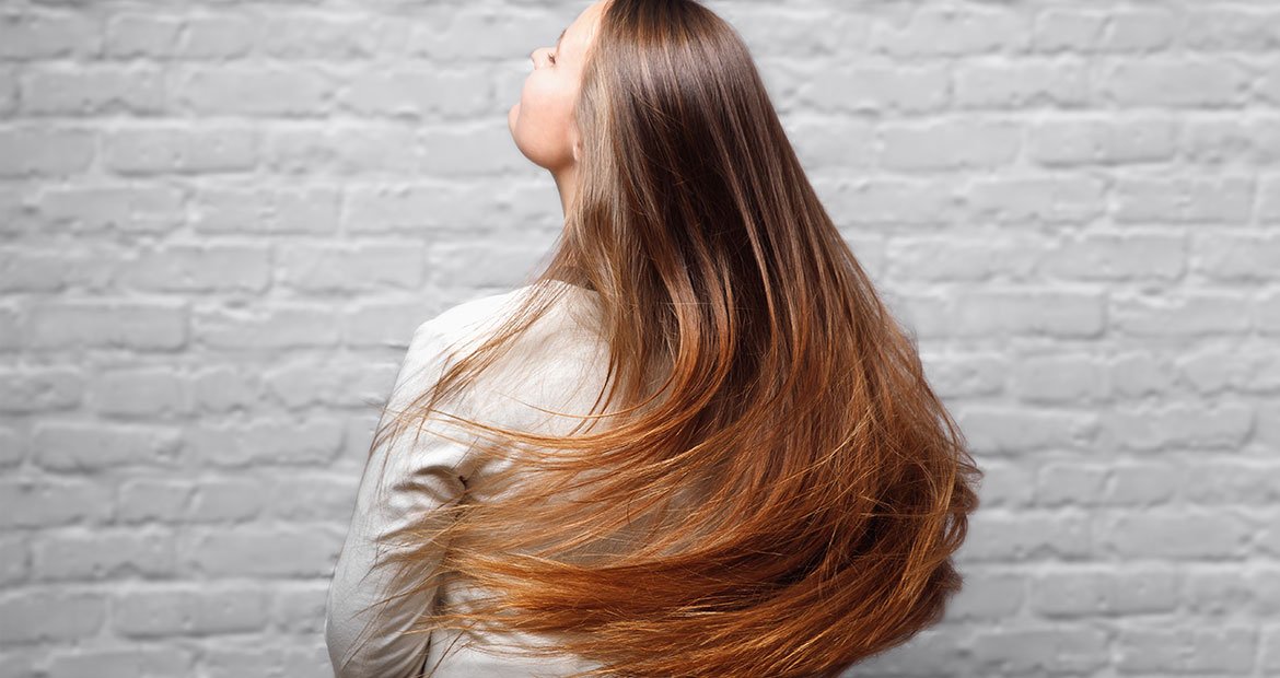 mulher de cabelos longos lisos com ombre hair acobreado